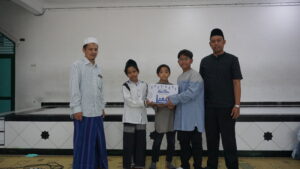 Perwakilan siswa, didampingi wakil kepala sekolah, menyerahkan paket baksos kepada panti asuhan anak