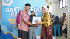 Senyum tulus parent siswa JHS ketika memberikan paket baksos kepada perwakilan warga