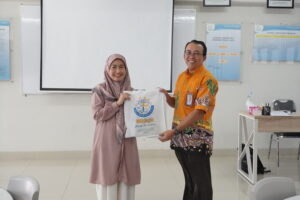 Ms. Aini menyerahkan merchandise GIS 3 Jogja kepada Pak Agus